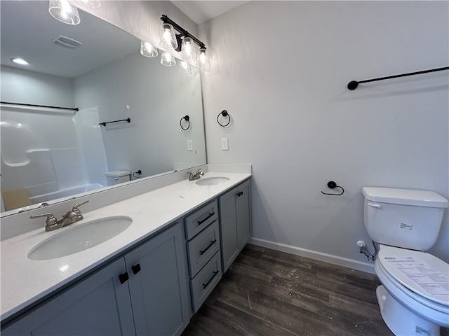 bathroom with toilet, a shower, vanity, and wood-type flooring