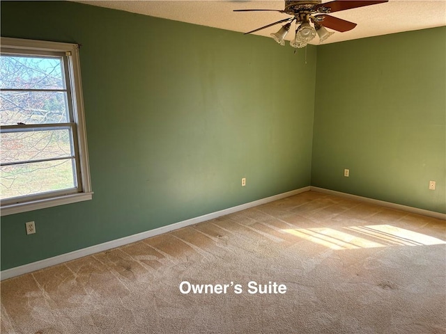 carpeted empty room with ceiling fan, a healthy amount of sunlight, and a textured ceiling