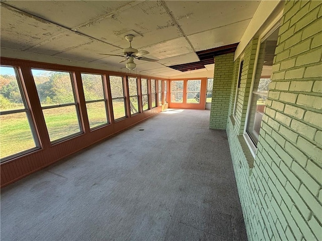 unfurnished sunroom featuring ceiling fan