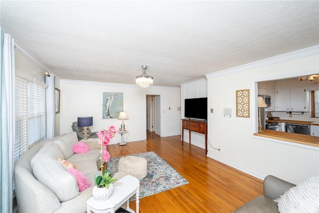 living room with an inviting chandelier, crown molding, hardwood / wood-style floors, and a textured ceiling