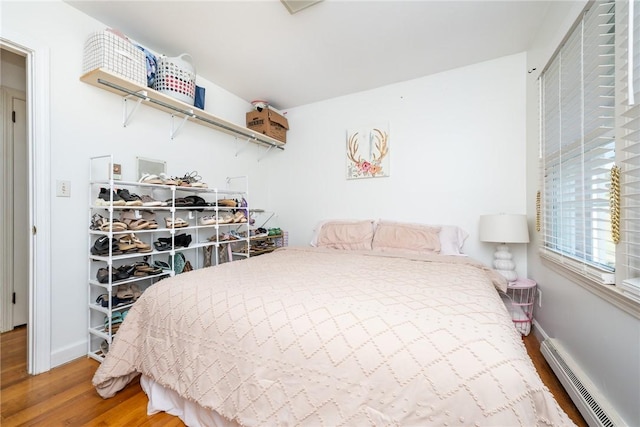 bedroom featuring hardwood / wood-style flooring and baseboard heating