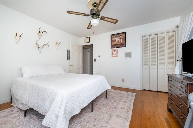 bedroom featuring ceiling fan, light hardwood / wood-style floors, and a closet