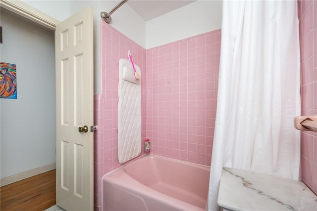 bathroom featuring wood-type flooring and shower / bath combination with curtain