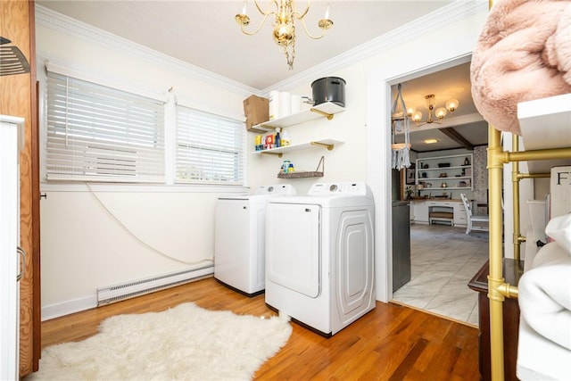 laundry room with a baseboard radiator, ornamental molding, light hardwood / wood-style flooring, and washing machine and dryer