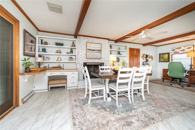 dining space featuring built in features, ceiling fan, built in desk, ornamental molding, and beamed ceiling