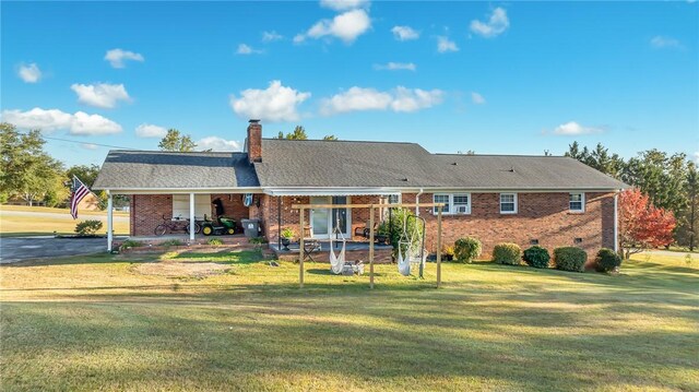 rear view of property featuring a yard and a patio