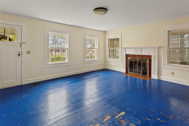 unfurnished living room featuring a brick fireplace and dark hardwood / wood-style flooring