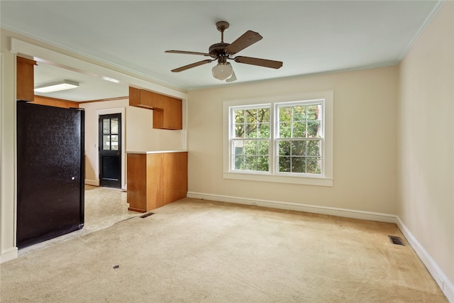 spare room with ornamental molding, light colored carpet, and ceiling fan