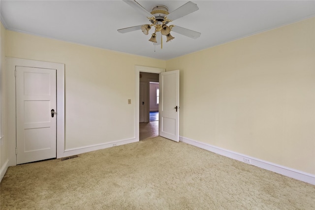 carpeted spare room with ceiling fan