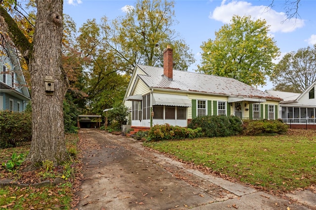 view of front of property featuring a front yard and a sunroom