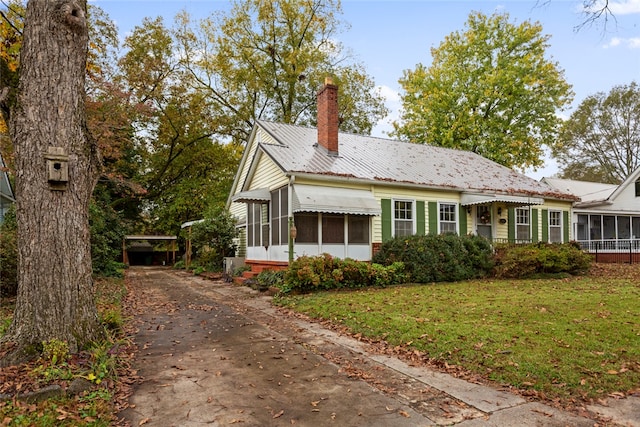 view of front of property with a front yard and a sunroom