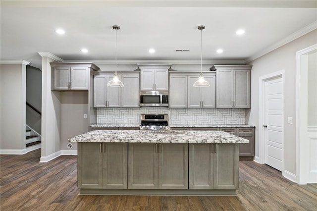 kitchen with stainless steel appliances, backsplash, a kitchen island with sink, dark wood-type flooring, and pendant lighting