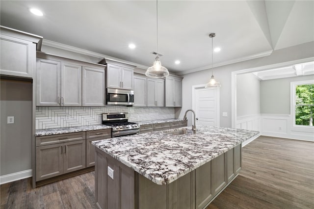 kitchen with decorative backsplash, appliances with stainless steel finishes, dark wood-type flooring, and decorative light fixtures