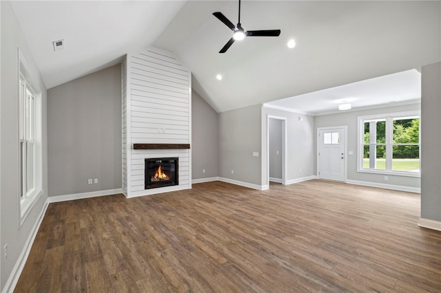 unfurnished living room with a large fireplace, lofted ceiling, ceiling fan, and wood-type flooring