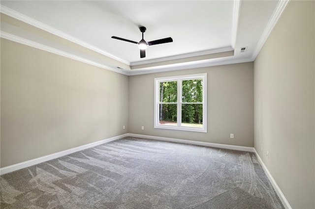 carpeted spare room with ceiling fan, a raised ceiling, and crown molding