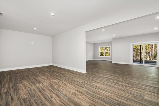 unfurnished room featuring a healthy amount of sunlight and dark hardwood / wood-style flooring