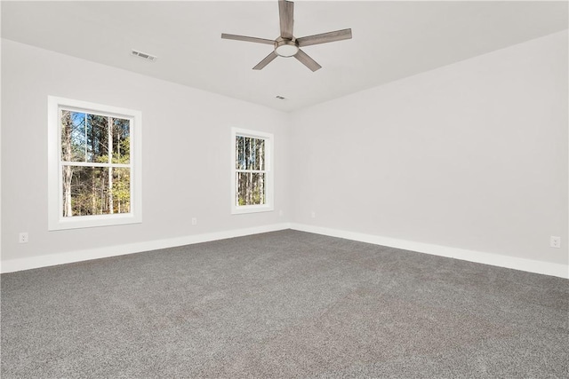 empty room featuring ceiling fan, carpet flooring, and a wealth of natural light