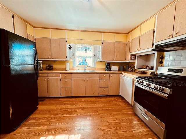 kitchen featuring sink, black refrigerator, white dishwasher, light hardwood / wood-style floors, and gas stove