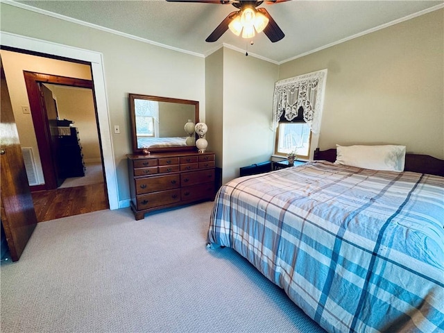 carpeted bedroom featuring crown molding and ceiling fan