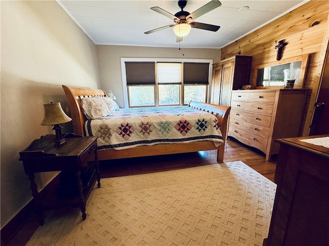 bedroom with wood-type flooring, ornamental molding, and ceiling fan