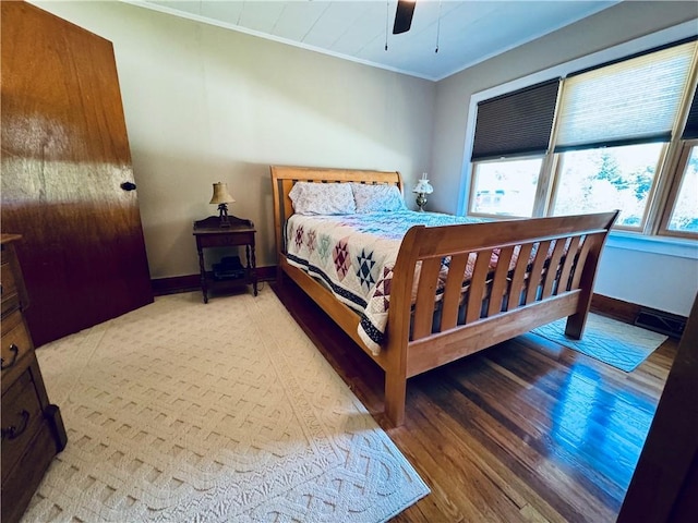 bedroom with crown molding, light hardwood / wood-style flooring, and ceiling fan