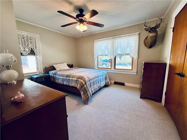 carpeted bedroom with crown molding, ceiling fan, and a textured ceiling