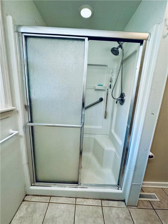 bathroom featuring tile patterned flooring and an enclosed shower