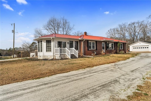 ranch-style home with a chimney, crawl space, metal roof, a garage, and an outdoor structure