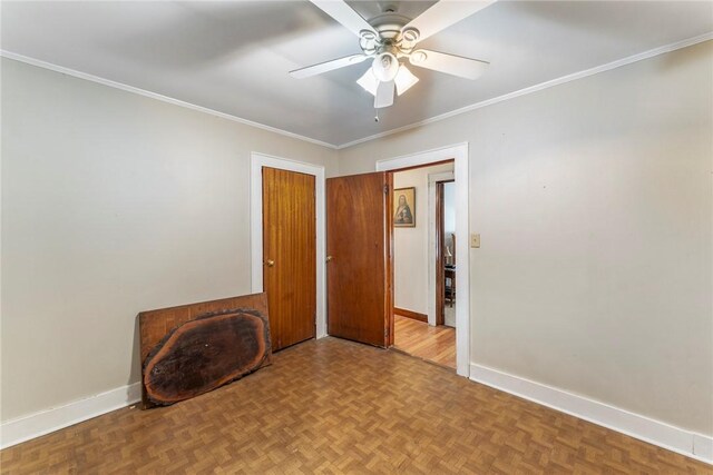 empty room featuring ceiling fan, baseboards, and ornamental molding