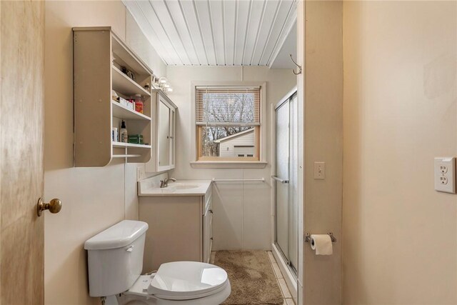 bathroom with toilet, a shower with door, and vanity