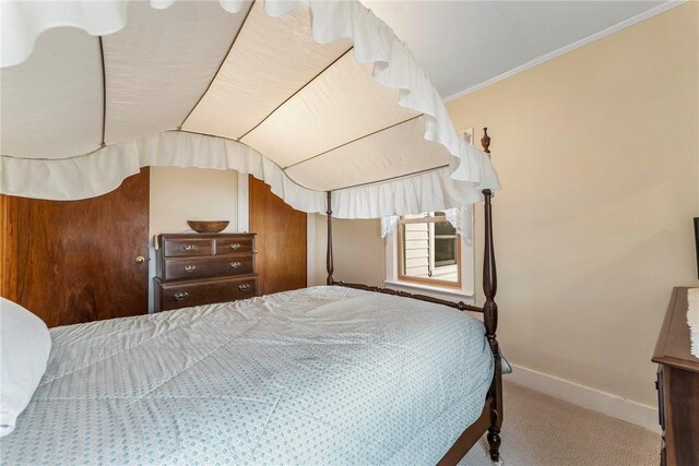 bedroom featuring ornamental molding, carpet flooring, vaulted ceiling, and baseboards