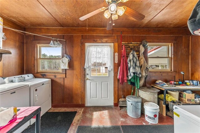 laundry area with laundry area, wood walls, and washing machine and clothes dryer