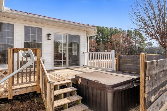 wooden deck with a hot tub and fence