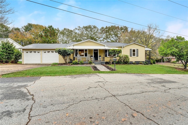 ranch-style house featuring a porch, a front lawn, and a garage