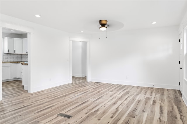 unfurnished living room with ceiling fan and light wood-type flooring