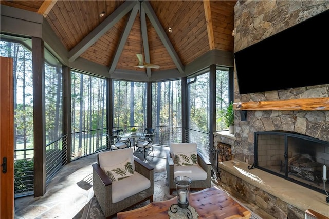 sunroom with lofted ceiling with beams, wooden ceiling, and a fireplace