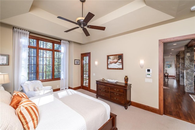 bedroom with a tray ceiling, ceiling fan, and hardwood / wood-style floors