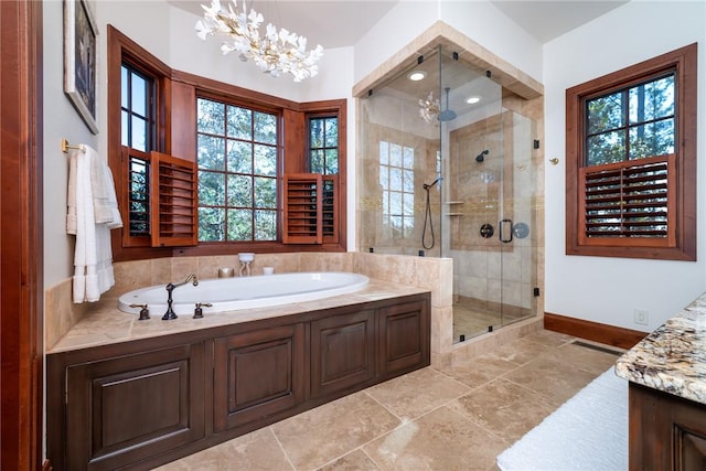 bathroom with vanity, a healthy amount of sunlight, separate shower and tub, and an inviting chandelier