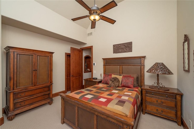 bedroom with ceiling fan, light colored carpet, and a high ceiling