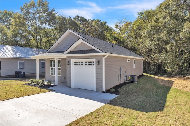 exterior space featuring a lawn, a garage, and central AC