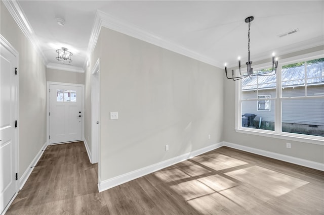 unfurnished dining area with a chandelier, hardwood / wood-style flooring, crown molding, and a healthy amount of sunlight