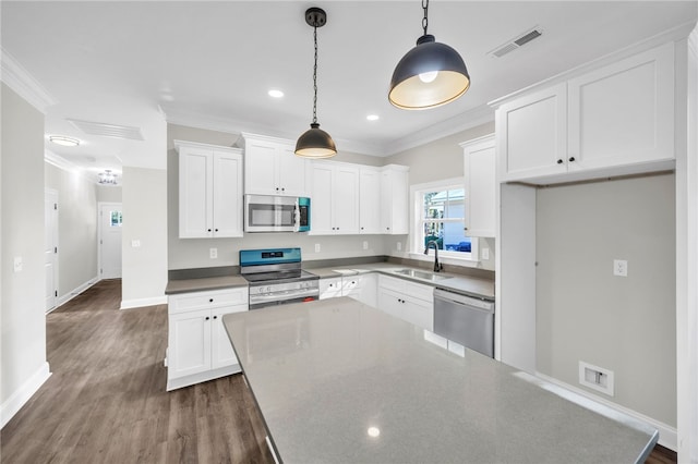 kitchen with sink, hanging light fixtures, appliances with stainless steel finishes, white cabinets, and ornamental molding