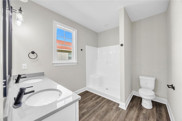 bathroom featuring vanity, toilet, wood-type flooring, and walk in shower