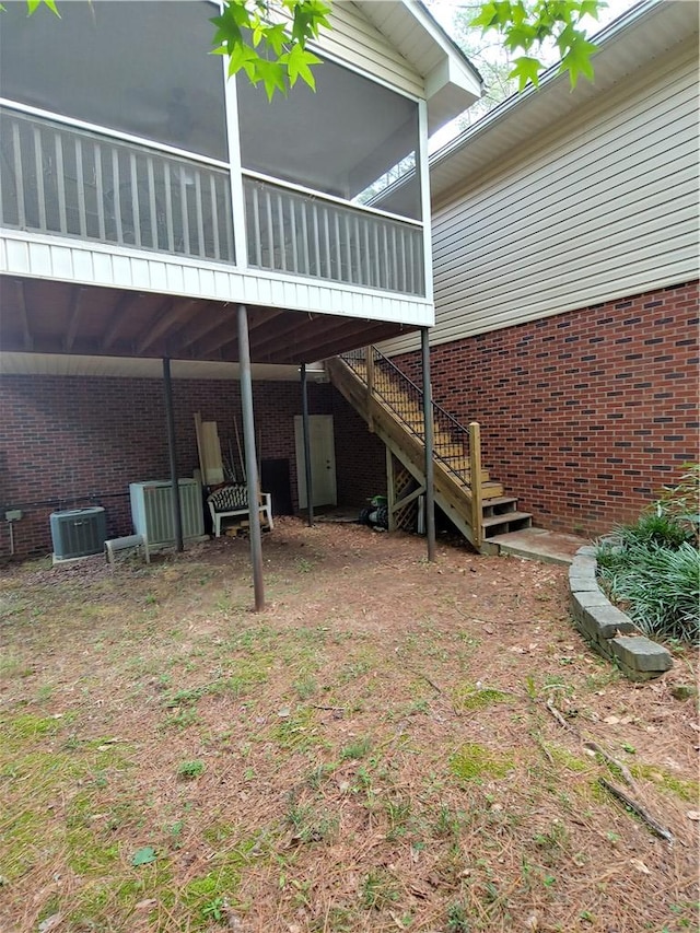 exterior space with central AC unit and a sunroom