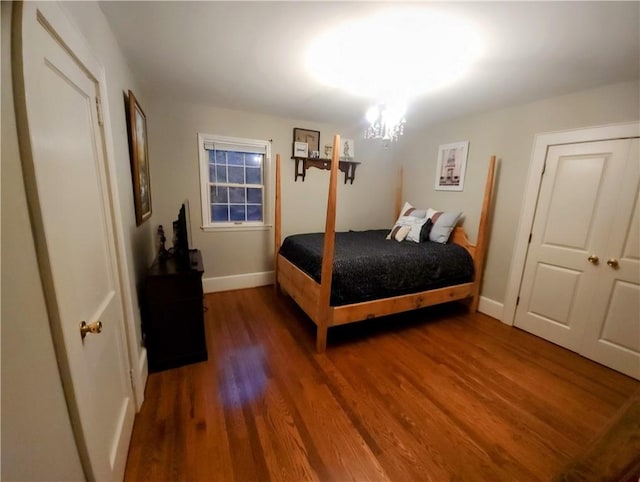 bedroom featuring dark wood-type flooring and a chandelier