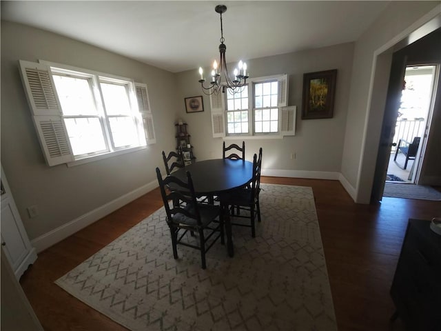 dining space featuring an inviting chandelier and dark wood-type flooring