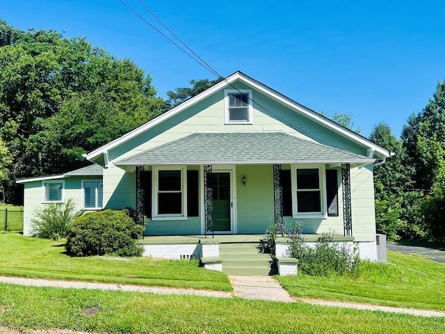 bungalow with covered porch and a front lawn