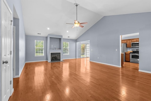 unfurnished living room with ceiling fan, high vaulted ceiling, and light hardwood / wood-style flooring