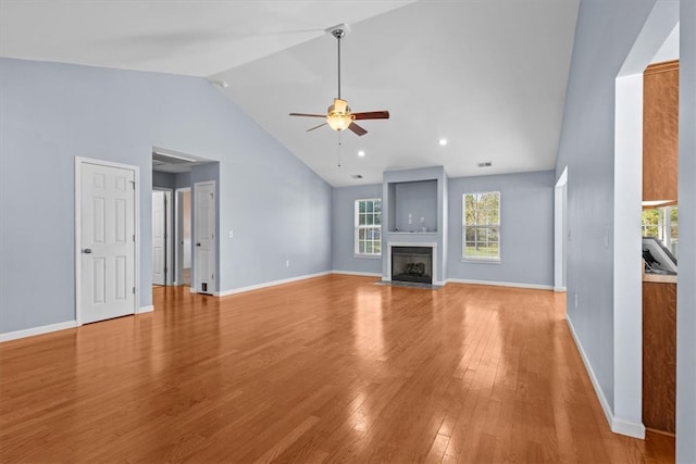 unfurnished living room featuring ceiling fan, light wood-type flooring, and high vaulted ceiling