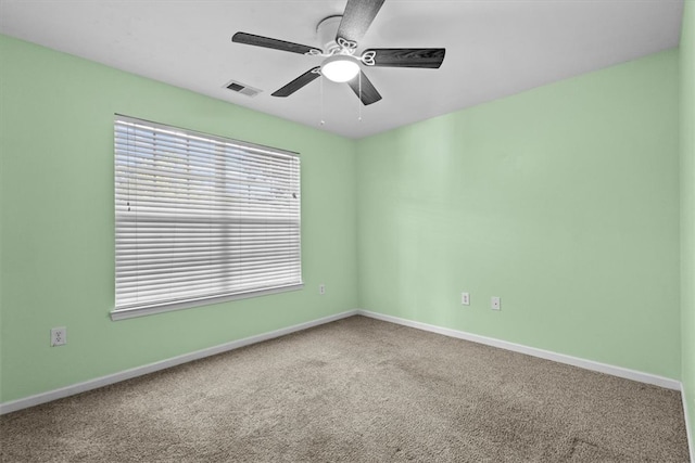 carpeted spare room featuring ceiling fan